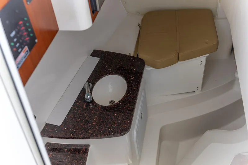 Slide: The Image of Spacious seating area on a 2015 Edgewater 280 CX boat, featuring cushioned benches. - 7