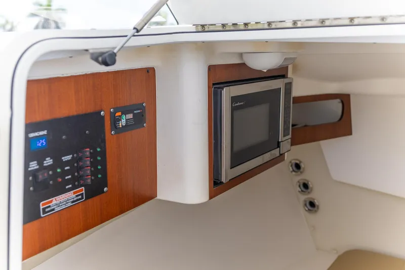 Slide: The Image of Interior of 2015 Edgewater 280 CX boat with microwave and control panel. - 8