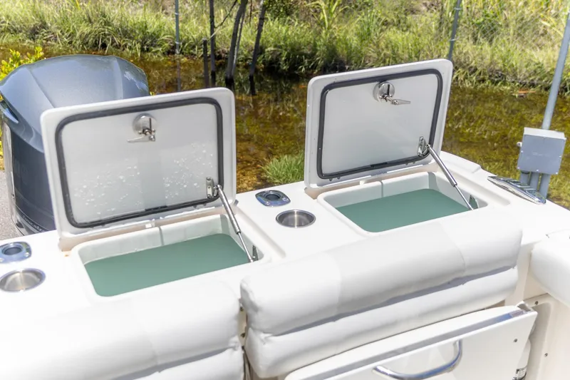 Slide: The Image of Open storage compartments on a 2015 Edgewater 280 CX boat, near water. - 9
