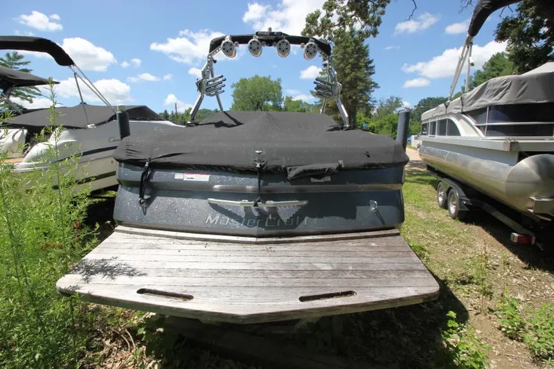 Slide: The Image of 2008 MasterCraft X-15 SS boat with cover, parked outdoors under a clear sky. - 4