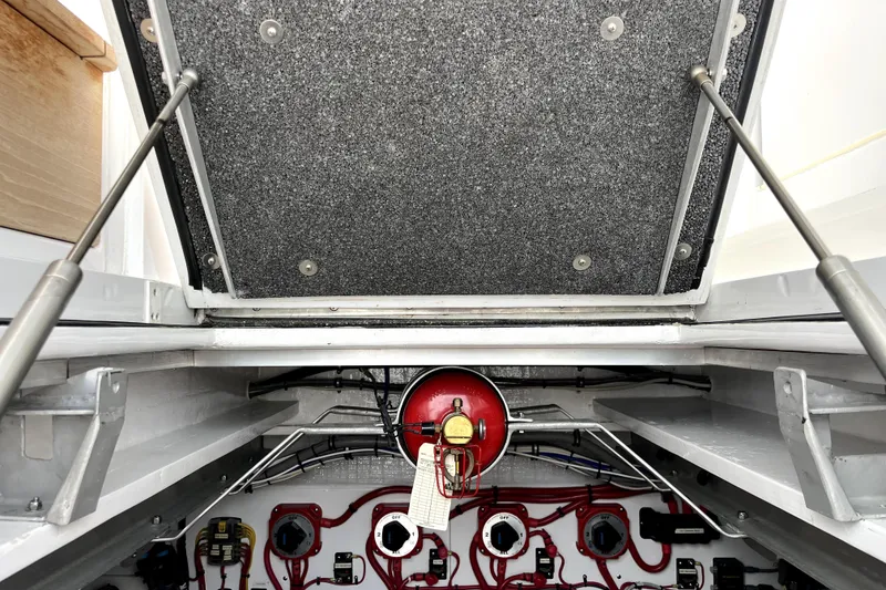 Slide: The Image of Engine compartment of a 2015 Huckins 45 boat, featuring mechanical components and wiring. - 12