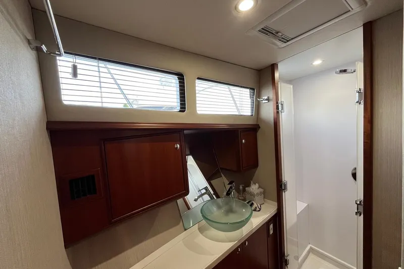 Slide: The Image of Luxurious bathroom in 2015 Huckins 45 yacht with glass sink and wooden cabinetry. - 19
