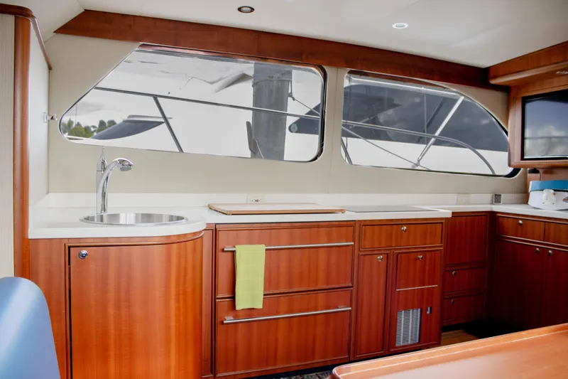 Slide: The Image of Luxurious 2015 Huckins 45 yacht interior with wooden cabinetry and modern kitchen amenities. - 23