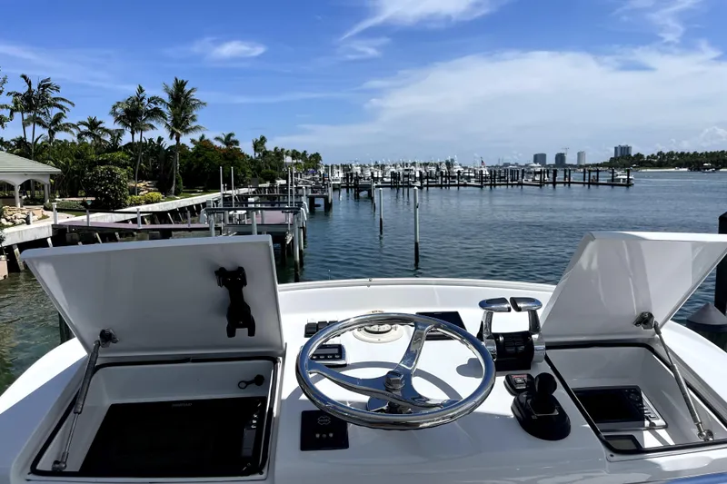 Slide: The Image of Helm view of 2015 Huckins 45 yacht at marina with palm trees and blue sky. - 27