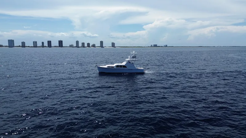 Slide: The Image of Huckins 45 yacht cruising on open sea with city skyline in background, 2015 model. - 3