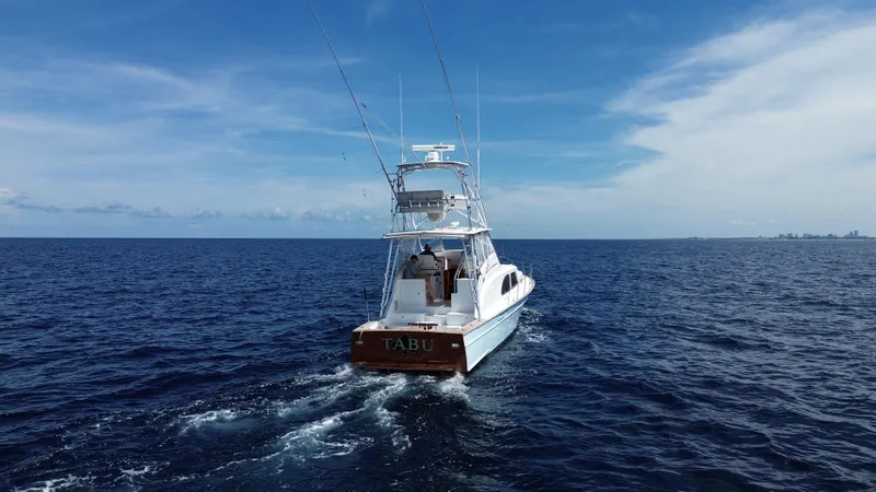 Slide: The Image of 2015 Huckins 45 yacht cruising on open ocean under clear blue sky. - 4