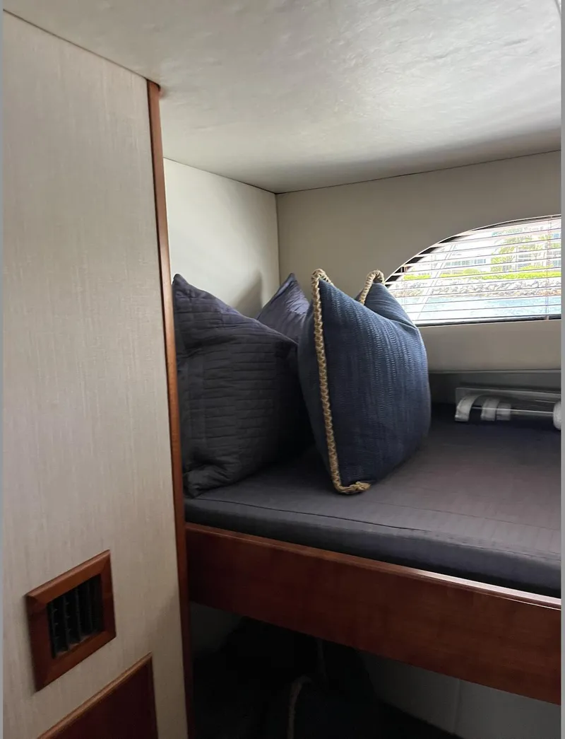 Slide: The Image of Cozy cabin interior of 2015 Huckins 45 yacht with plush pillows and window view. - 9