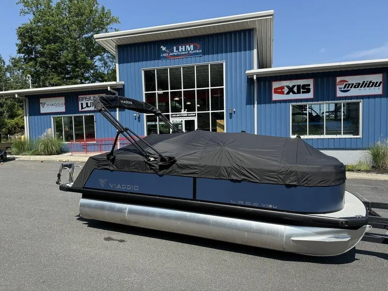 Slide: The Image of 2026 Viaggio V18U pontoon boat covered, parked outside LHM Marine dealership. - 10