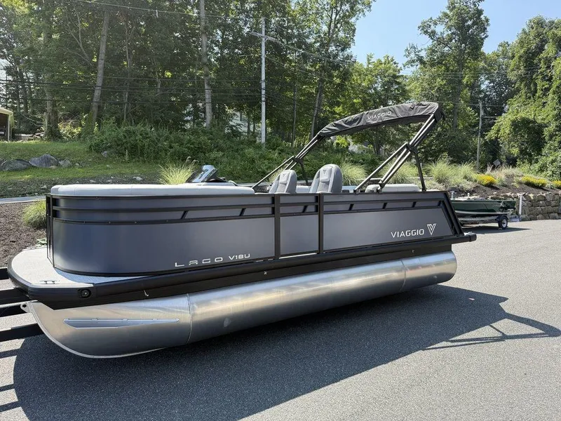 Slide: The Image of 2026 Viaggio V18U pontoon boat parked on a sunny day, surrounded by greenery. - 3