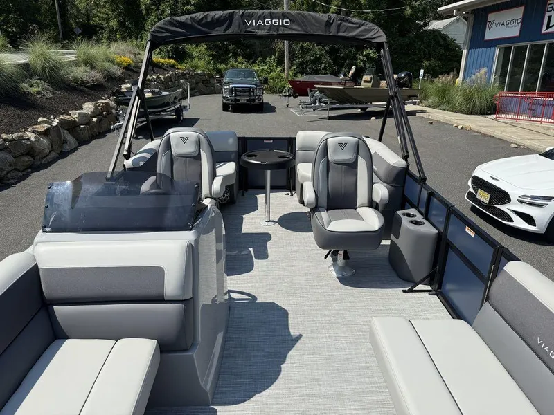 Slide: The Image of 2026 Viaggio V18U pontoon boat with sleek seating and modern design in a dealership setting. - 4