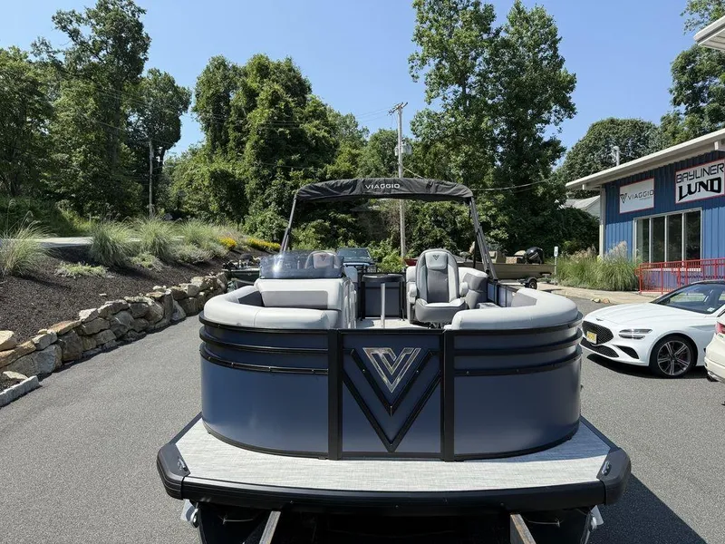 Slide: The Image of 2026 Viaggio V18U pontoon boat displayed outdoors near dealership. - 6