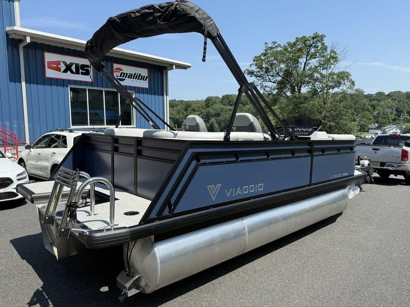 Slide: The Image of 2026 Viaggio V18U pontoon boat parked outside dealership, featuring sleek design and modern amenities. - 9