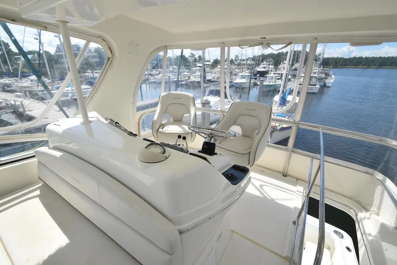 Slide: The Image of 2007 Silverton 38 Convertible yacht interior with helm, overlooking marina. - 14