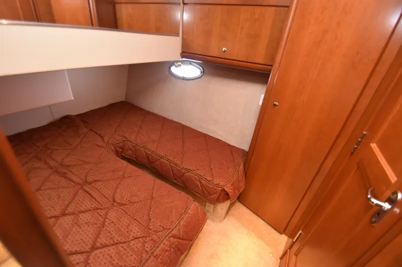 Slide: The Image of 2007 Silverton 38 Convertible cabin with twin beds and wooden cabinetry. - 22