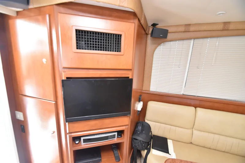 Slide: The Image of Interior of 2007 Silverton 38 Convertible yacht with TV, beige seating, and wooden cabinetry. - 28