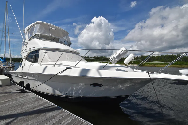 Slide: The Image of 2007 Silverton 38 Convertible yacht docked under a blue sky with clouds. - 4