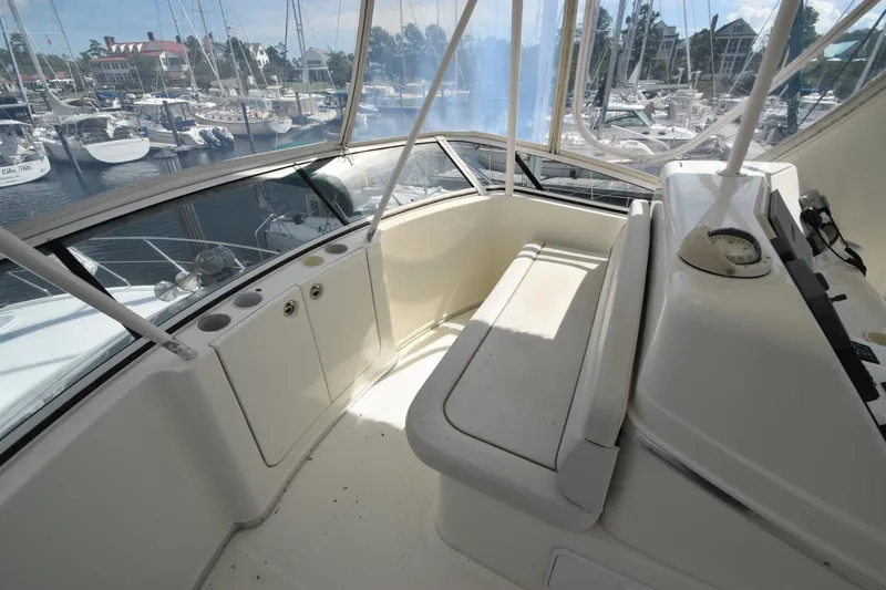Slide: The Image of 2007 Silverton 38 Convertible yacht interior with marina view, featuring helm and seating area. - 8