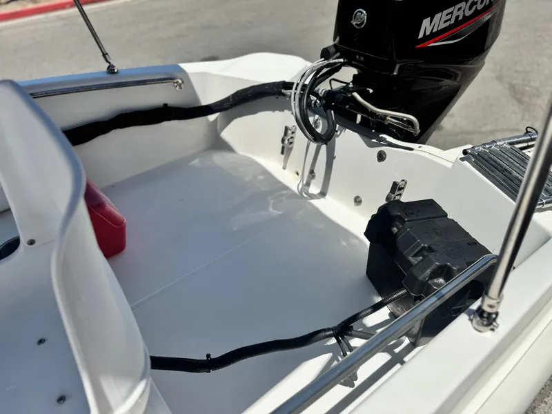 Slide: The Image of 2021 Boston Whaler 130 Super Sport boat interior with Mercury engine and battery compartment. - 11