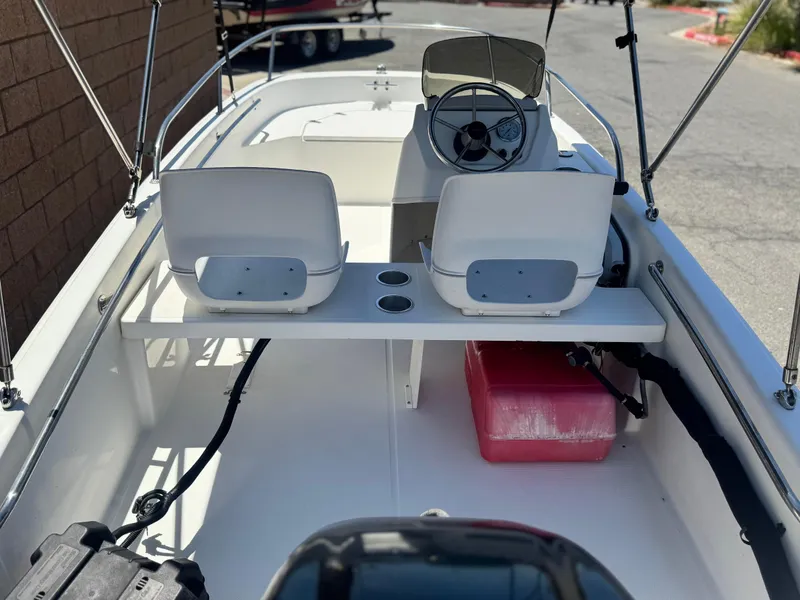 Slide: The Image of 2021 Boston Whaler 130 Super Sport interior with steering wheel and seating. - 12
