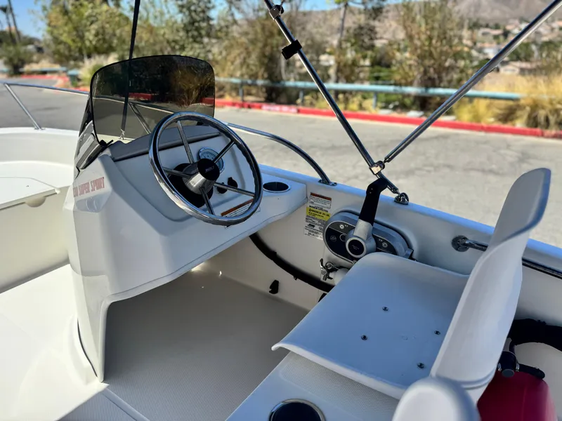 Slide: The Image of 2021 Boston Whaler 130 Super Sport boat interior with steering wheel and seating. - 13
