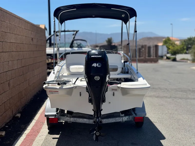 Slide: The Image of 2021 Boston Whaler 130 Super Sport boat with Mercury 40 engine, parked outdoors. - 4