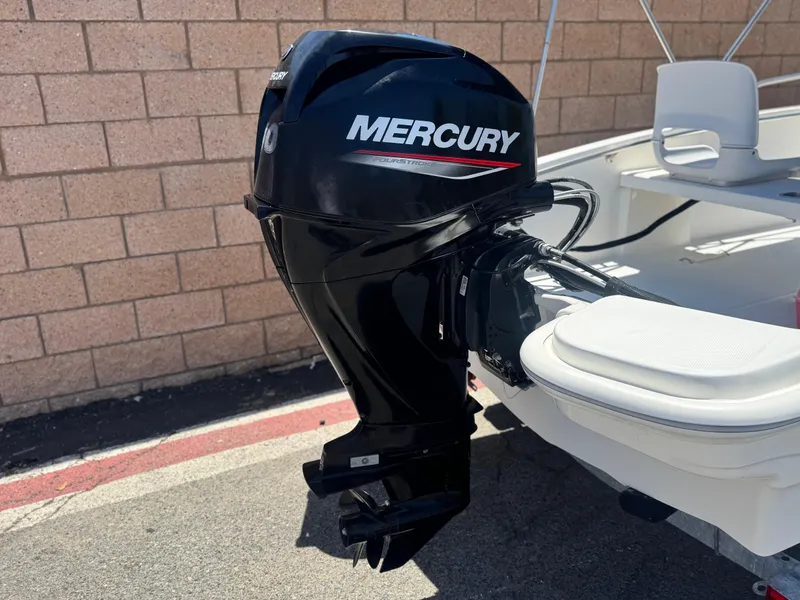 Slide: The Image of 2021 Boston Whaler 130 Super Sport with Mercury outboard motor, parked by brick wall. - 6