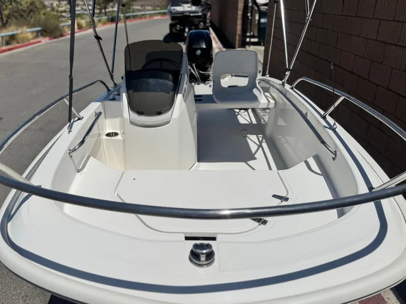 Slide: The Image of 2021 Boston Whaler 130 Super Sport boat, white interior, docked outdoors. - 7