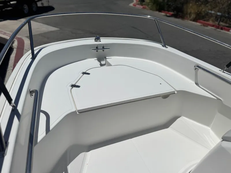 Slide: The Image of 2021 Boston Whaler 130 Super Sport boat interior with white seating and storage compartment. - 8