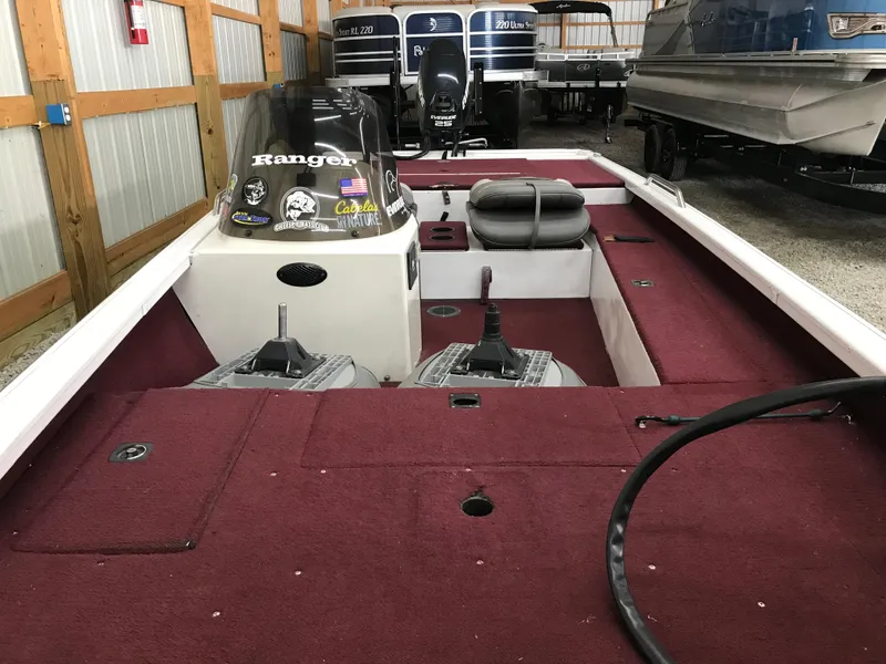 Slide: The Image of 1995 Ranger Cherokee 17' boat interior with maroon carpet and storage compartments. - 10