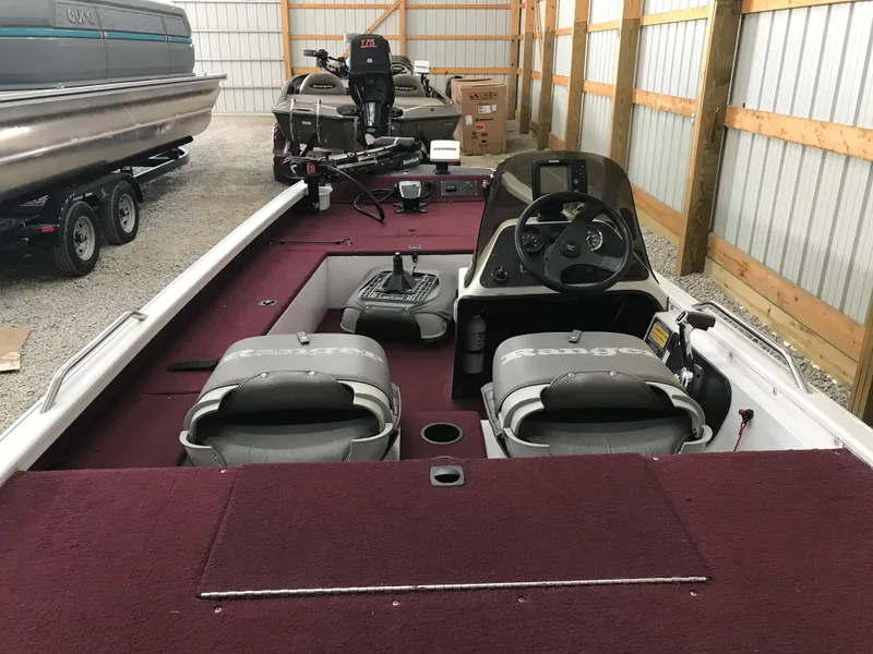Slide: The Image of 1995 Ranger Cherokee 17' boat interior with maroon carpet and dual seats in storage. - 11