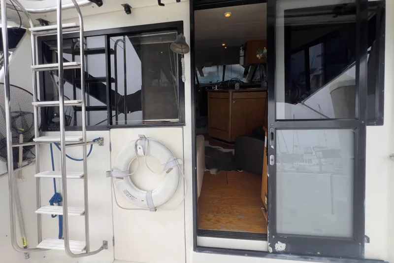 Slide: The Image of 1999 Bayliner 3988 Command Bridge Motoryacht with open cabin door and ladder. - 11