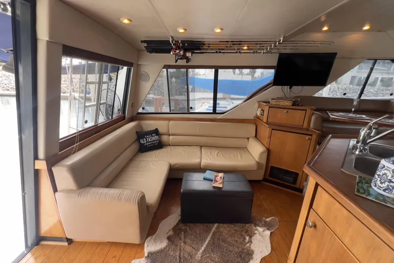 Slide: The Image of 1999 Bayliner 3988 Command Bridge Motoryacht interior with beige seating, TV, and kitchenette. - 14