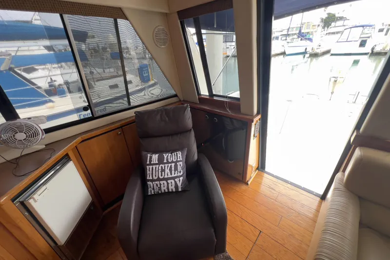 Slide: The Image of 1999 Bayliner 3988 Command Bridge Motoryacht interior with chair and marina view. - 16