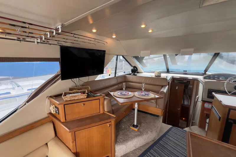 Slide: The Image of Interior of 1999 Bayliner 3988 Command Bridge Motoryacht with seating, table, and TV. - 19