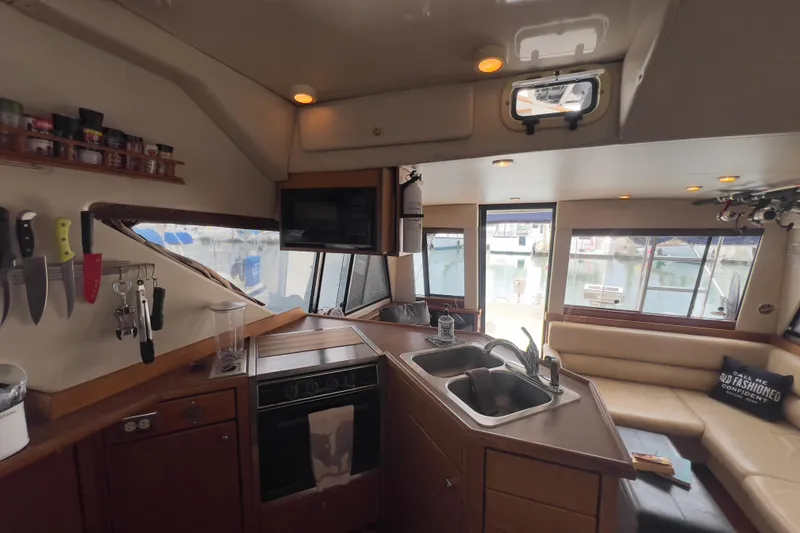 Slide: The Image of Interior of 1999 Bayliner 3988 Command Bridge Motoryacht with kitchen and seating area. - 21