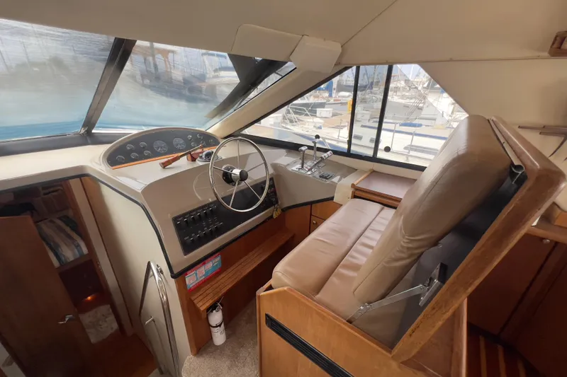 Slide: The Image of 1999 Bayliner 3988 Command Bridge Motoryacht helm with steering wheel and control panel. - 24