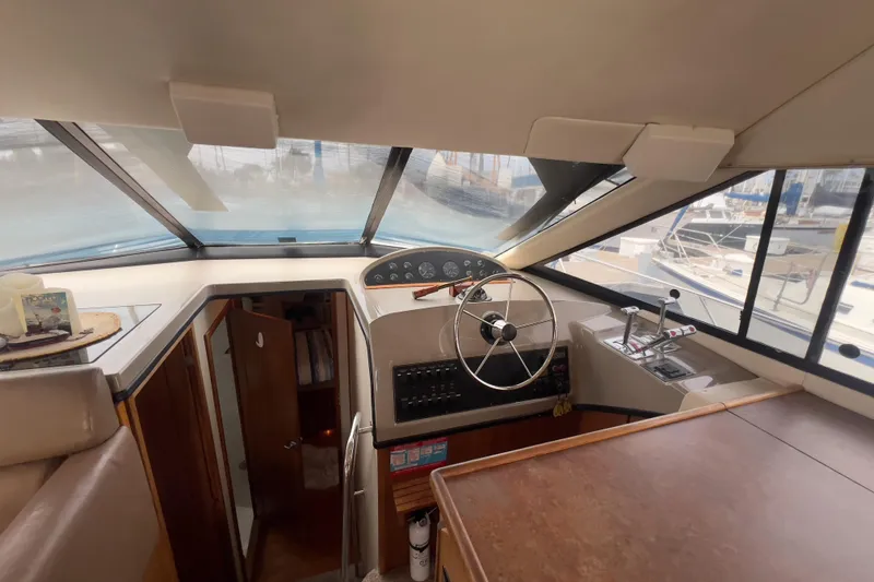 Slide: The Image of 1999 Bayliner 3988 Command Bridge Motoryacht helm with steering wheel and control panel. - 25