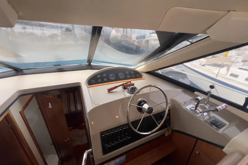 Slide: The Image of 1999 Bayliner 3988 Command Bridge Motoryacht helm with steering wheel and control panel. - 26