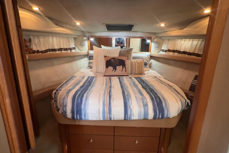 Slide: The Image of Cozy bedroom in 1999 Bayliner 3988 Command Bridge Motoryacht with striped bedding and decorative pillows. - 30