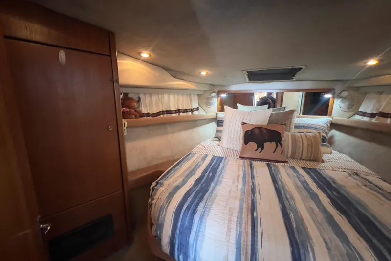Slide: The Image of Cozy bedroom in 1999 Bayliner 3988 Command Bridge Motoryacht with striped bedding and decorative pillows. - 31