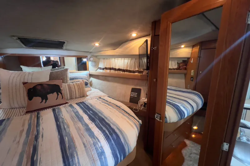 Slide: The Image of Cozy bedroom interior of 1999 Bayliner 3988 Command Bridge Motoryacht with striped bedding. - 32