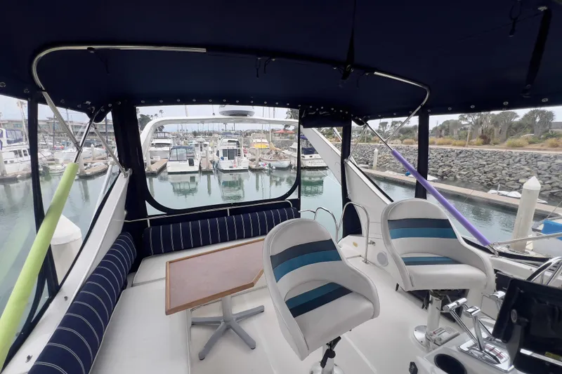 Slide: The Image of 1999 Bayliner 3988 Command Bridge Motoryacht interior with marina view, featuring seating and helm. - 5