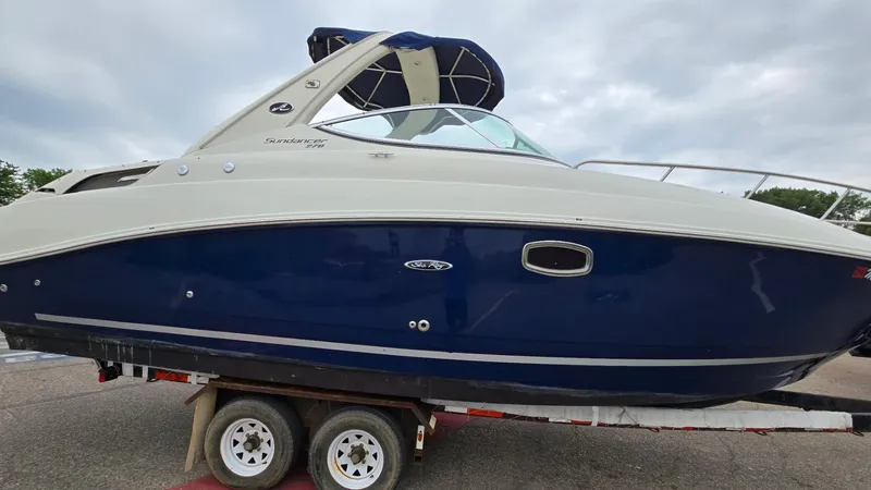 Slide: The Image of 2009 Sea Ray 270 Sundancer boat on trailer, featuring sleek blue and white design. - 3