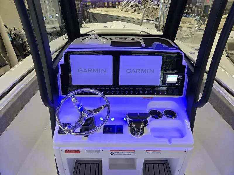 Slide: The Image of 2026 Sea Hunt Ultra 275 SE boat dashboard with dual Garmin displays and illuminated controls. - 13