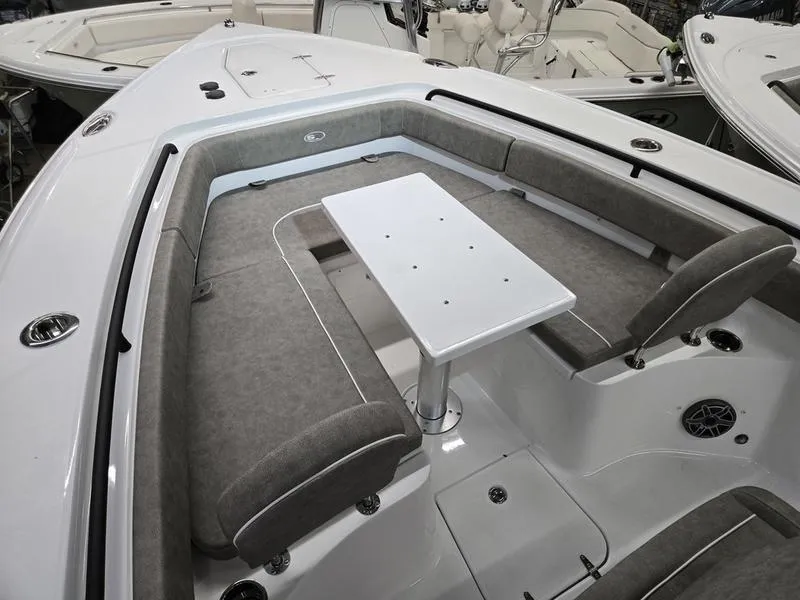 Slide: The Image of 2026 Sea Hunt Ultra 275 SE boat interior with cushioned seating and a central table. - 8