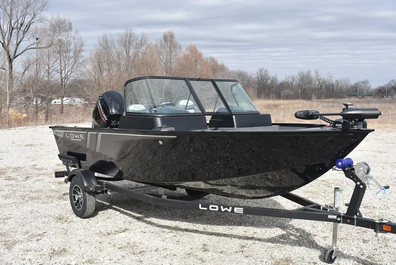 Slide: The Image of 2025 Lowe FM 1675 WT fishing boat on trailer, parked outdoors. - 1
