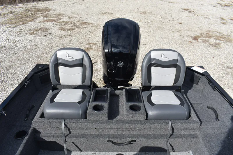 Slide: The Image of 2025 Lowe FM 1675 WT boat interior with dual seats and motor, on gravel surface. - 13
