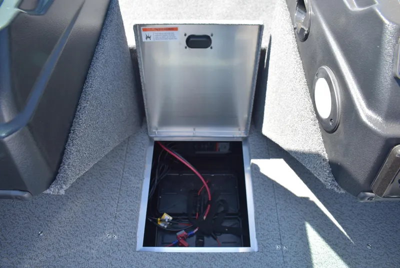 Slide: The Image of 2025 Lowe FM 1675 WT boat battery compartment with open hatch and visible wiring. - 15