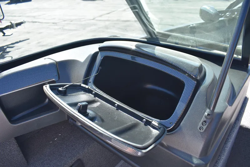Slide: The Image of 2025 Lowe FM 1675 WT boat dashboard with open storage compartment. - 16