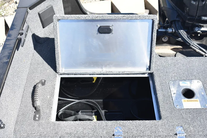 Slide: The Image of Open storage compartment on a 2025 Lowe FM 1675 WT boat, showing interior details. - 19